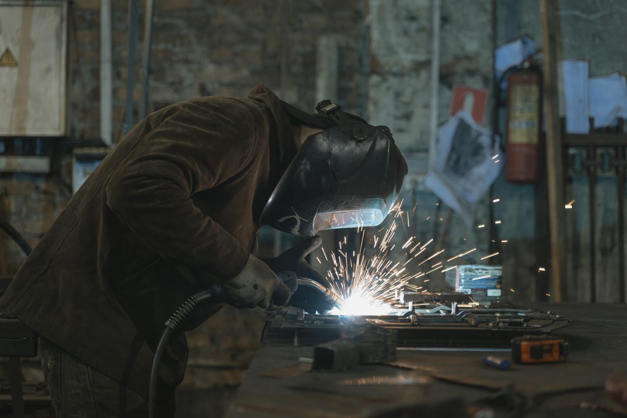 Welder making an on-site repair with sparks flying